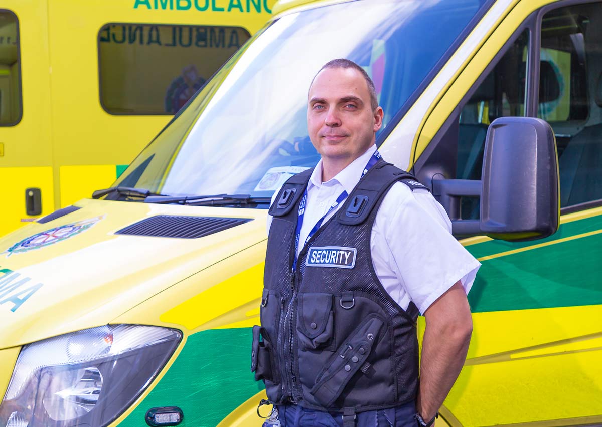 Bidvest Noonan security officer in front of an ambulance. Bidvest Noonan provide security services to the healthcare sector