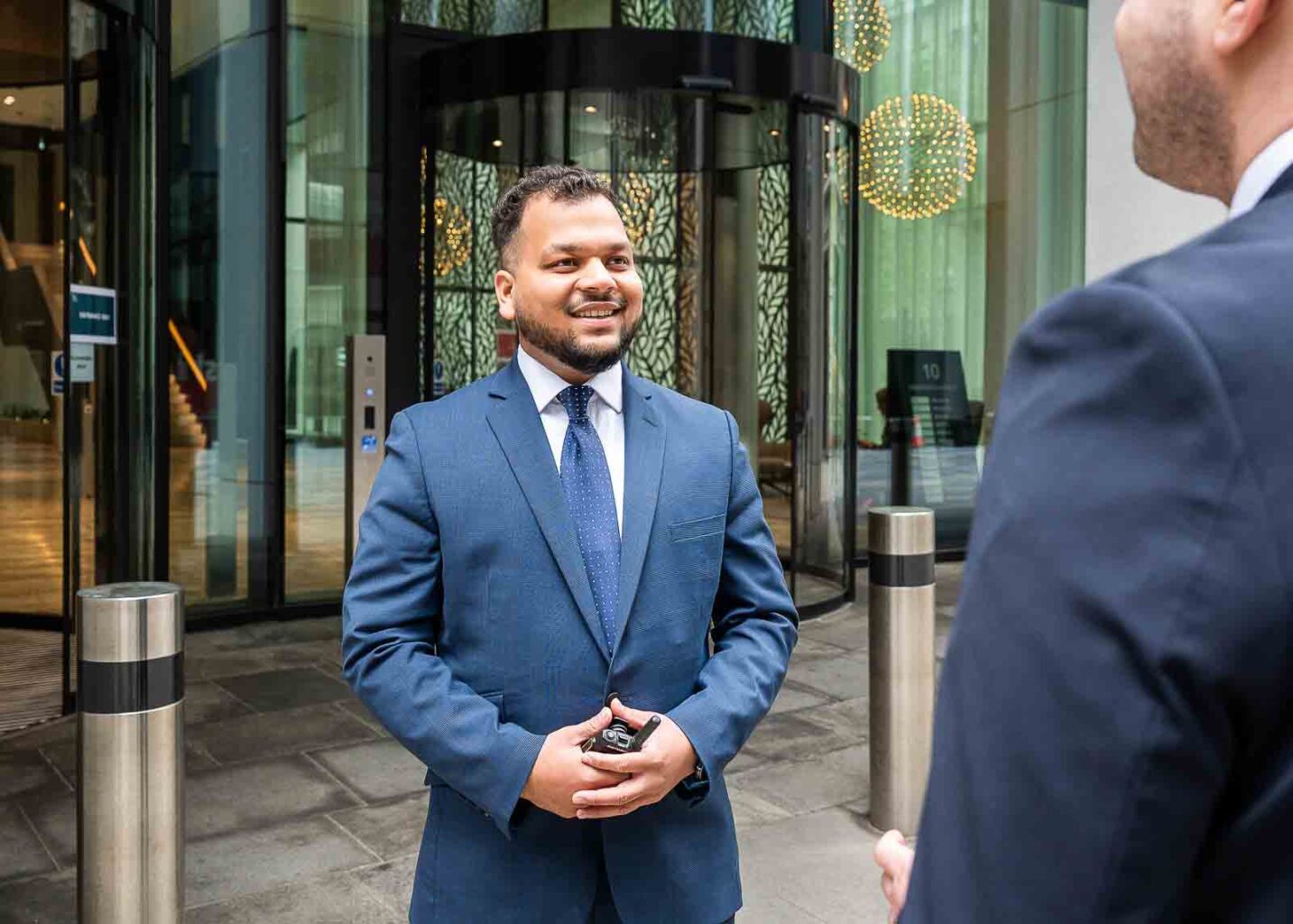 Security officer welcoming visitor in front of a building