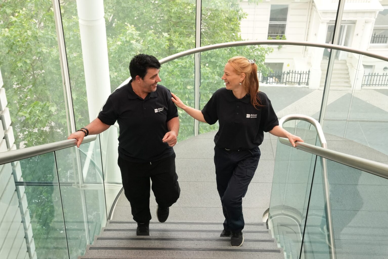 cleaning team of two walking upstairs talking