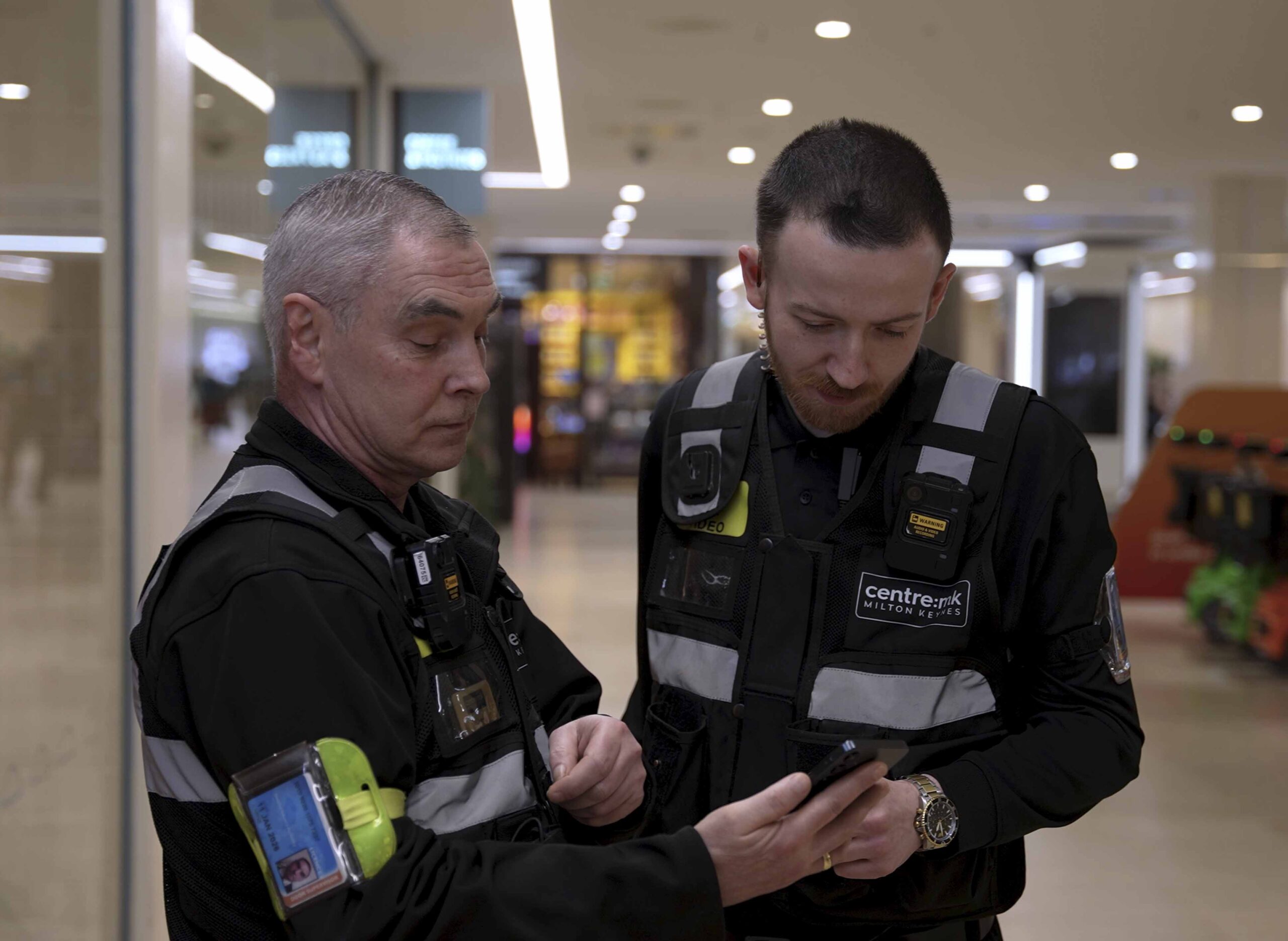Bidvest Noonan security officers at a shopping centre using a mobile device to monitor patrol activity and update Task, the company’s digital operations platform.
